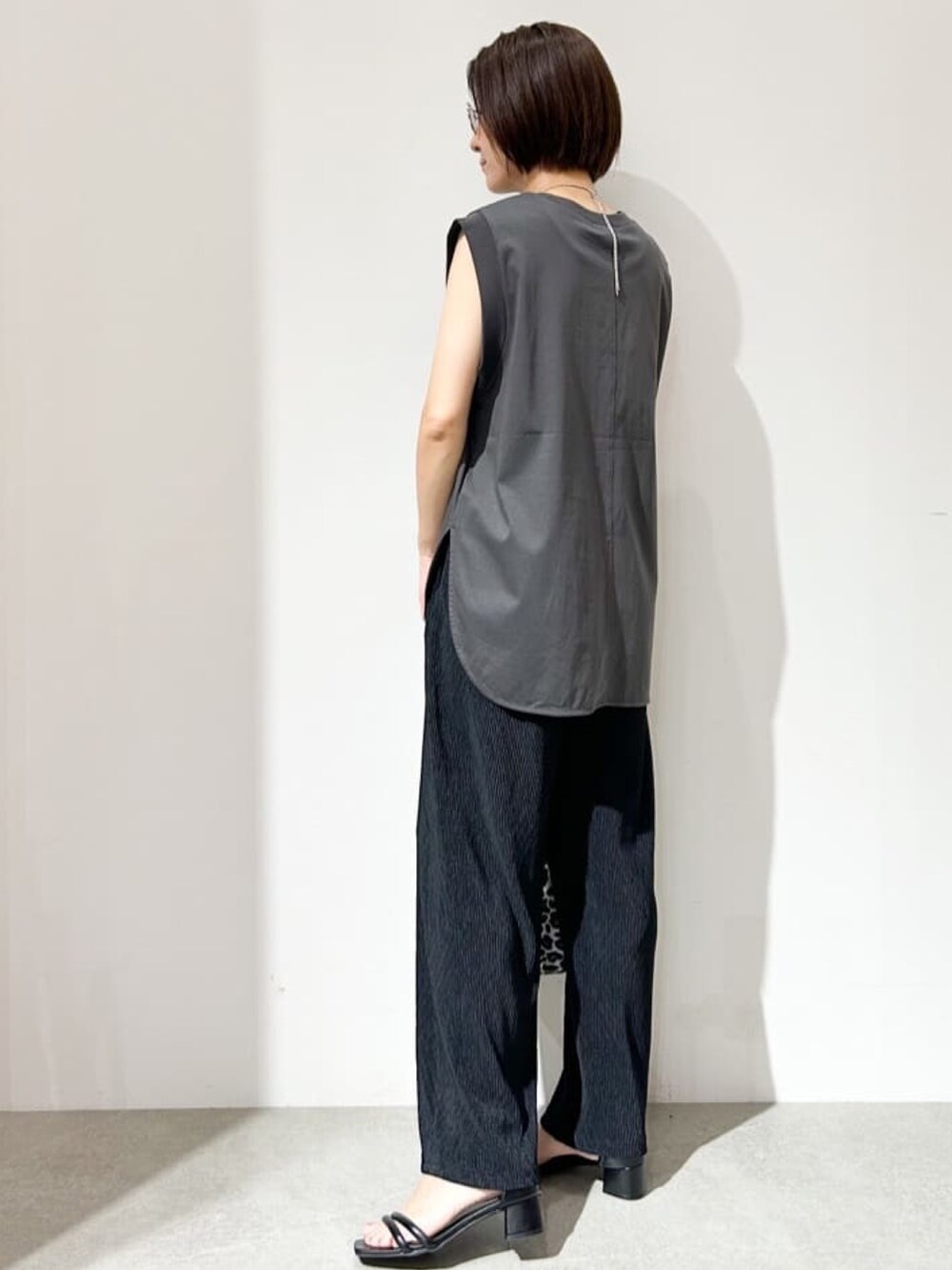 ブラック系のその他パンツ、ホワイト系のショルダーバッグ、ブラック系のサンダルを着用したレディースの夏コーディネートの2枚目の写真