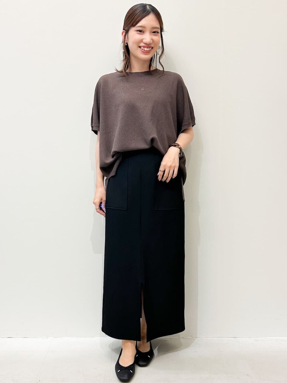 ブラウン系のニット/セーター、ブラック系のパンプス、ブラック系のスカートを着用したレディースの夏コーディネートの5枚目の写真