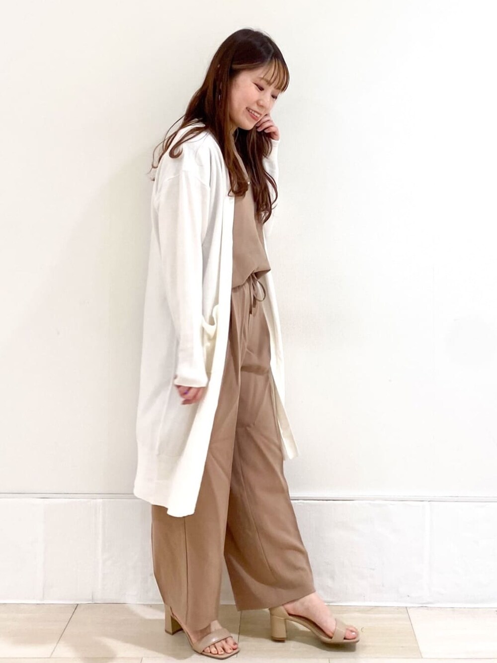 ベージュ系のシャツ/ブラウス、ベージュ系のサンダル、ホワイト系のカーディガン/ボレロを着用したレディースの春コーディネートの3枚目の写真