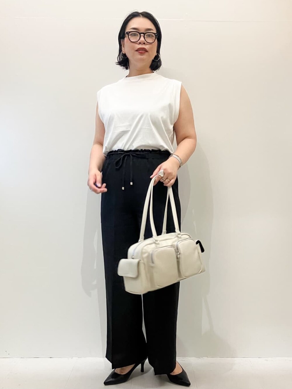 ホワイト系のTシャツ/カットソー、ブラック系のベスト、ブラック系のその他パンツを着用したレディースの夏コーディネートの6枚目の写真