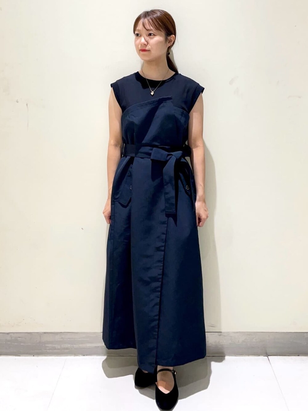 ブルー系のワンピース、ブラック系のパンプス、ブラック系のショルダーバッグを着用したレディースの秋コーディネートの3枚目の写真