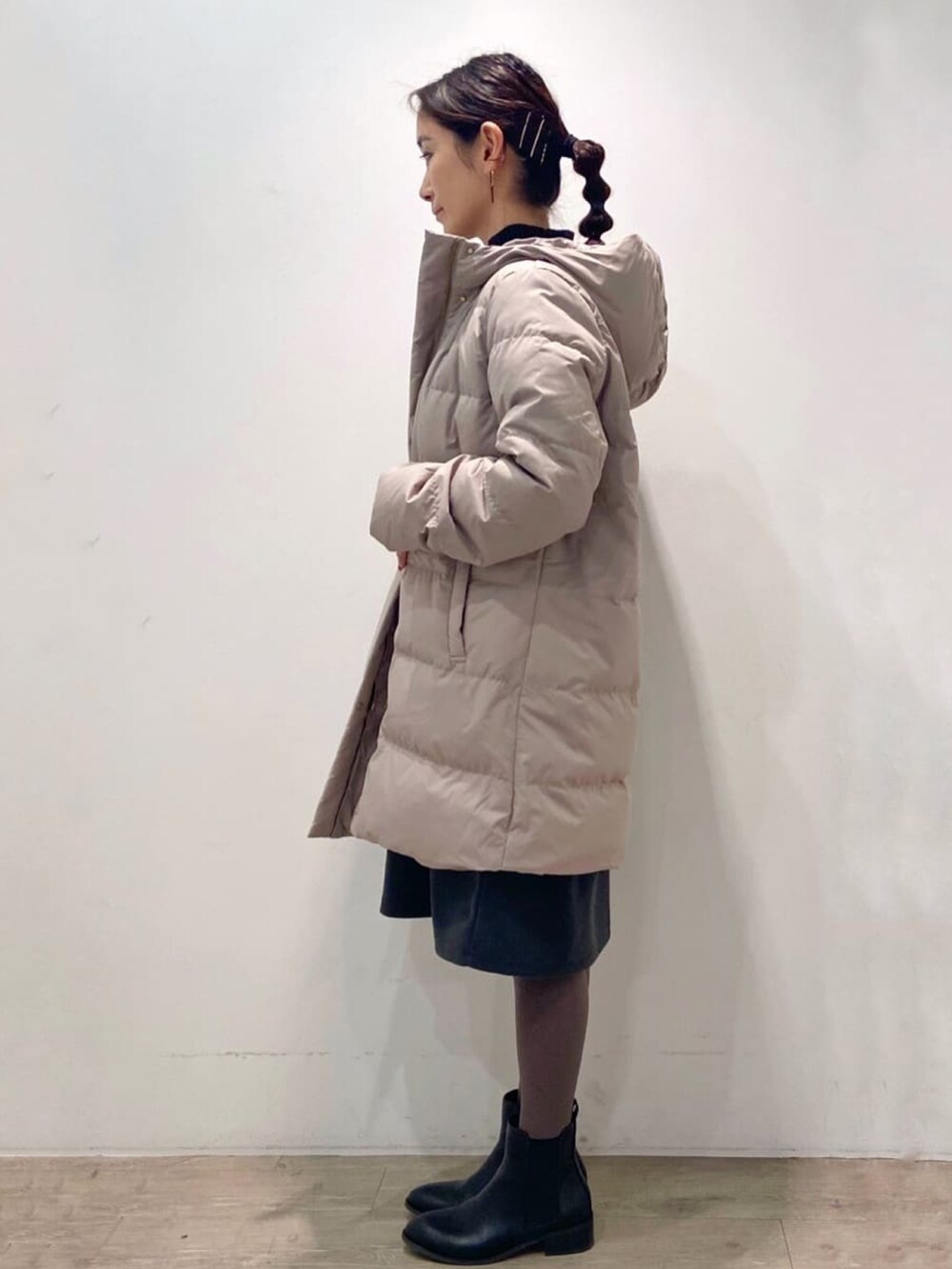 ベージュ系のダウンジャケット/コート、グレー系のワンピース、ブラック系のブーツを着用したレディースの冬コーディネートの3枚目の写真