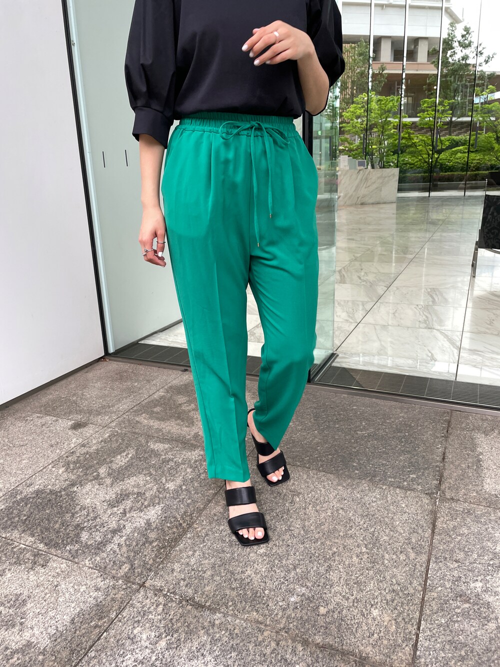 ブラック系のTシャツ/カットソー、ブルー系のその他パンツ、ブラック系のサンダルを着用したレディースの春コーディネートの3枚目の写真