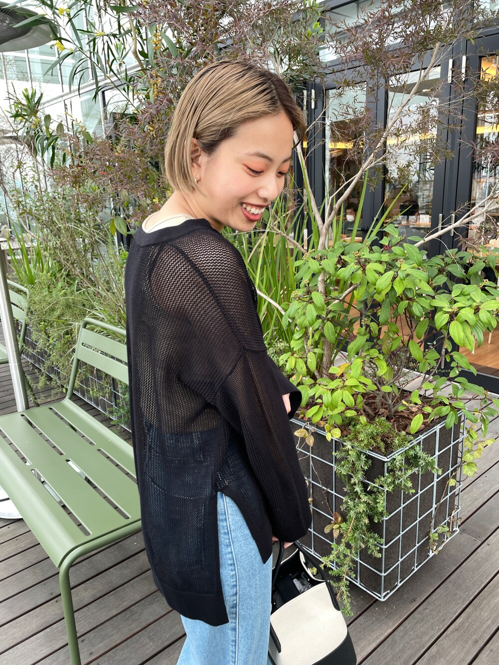 ブラック系のニット/セーター、ベージュ系のタンクトップ、ブルー系のその他パンツを着用したレディースの春コーディネートの3枚目の写真