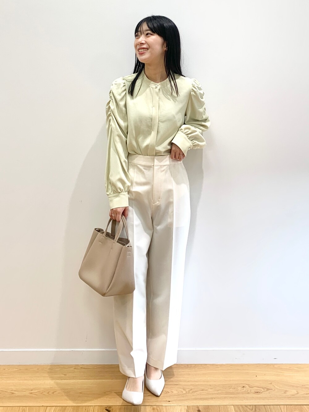 ベージュ系のトレンチコート、イエロー系のシャツ/ブラウス、ホワイト系のその他パンツを着用したレディースの春コーディネートの4枚目の写真
