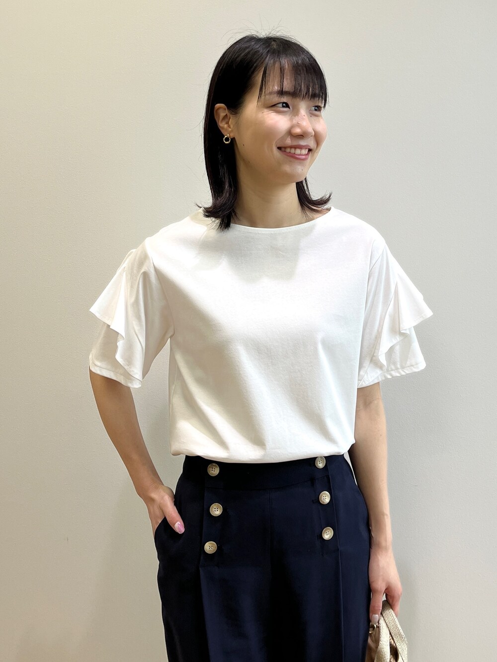 ブラウン系のサンダル、ホワイト系のTシャツ/カットソー、ゴールド系のトートバッグを着用したレディースの春コーディネートの4枚目の写真