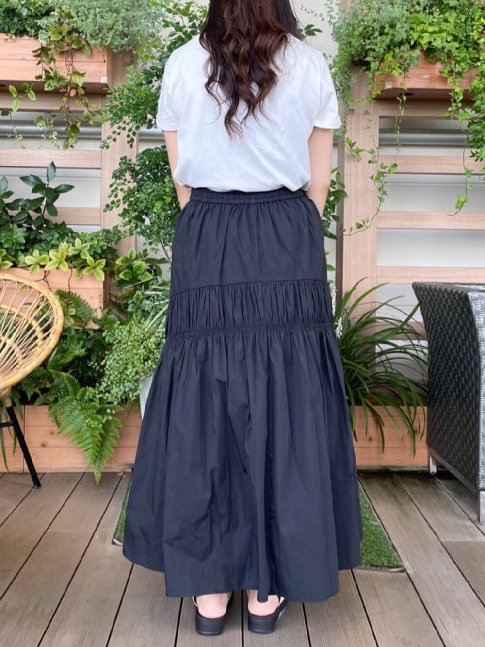 ホワイト系のTシャツ/カットソー、ブラック系のスカート、ブルー系のハンドバッグを着用したレディースの夏コーディネートの3枚目の写真