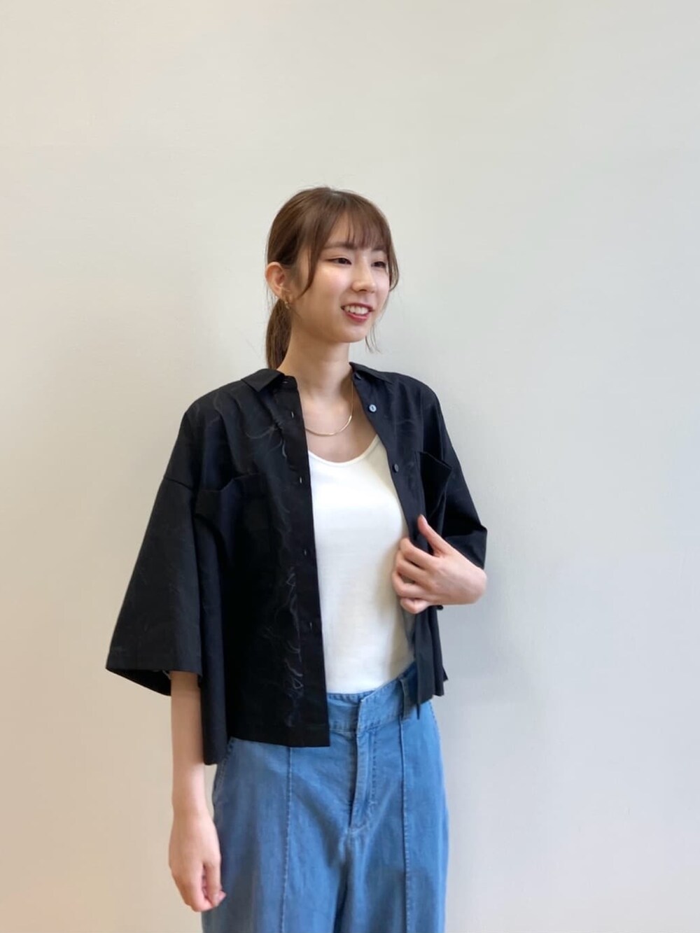 ブルー系のデニムパンツ、ブラック系のサンダル、ブラック系のシャツ/ブラウスを着用したレディースの夏コーディネートの5枚目の写真