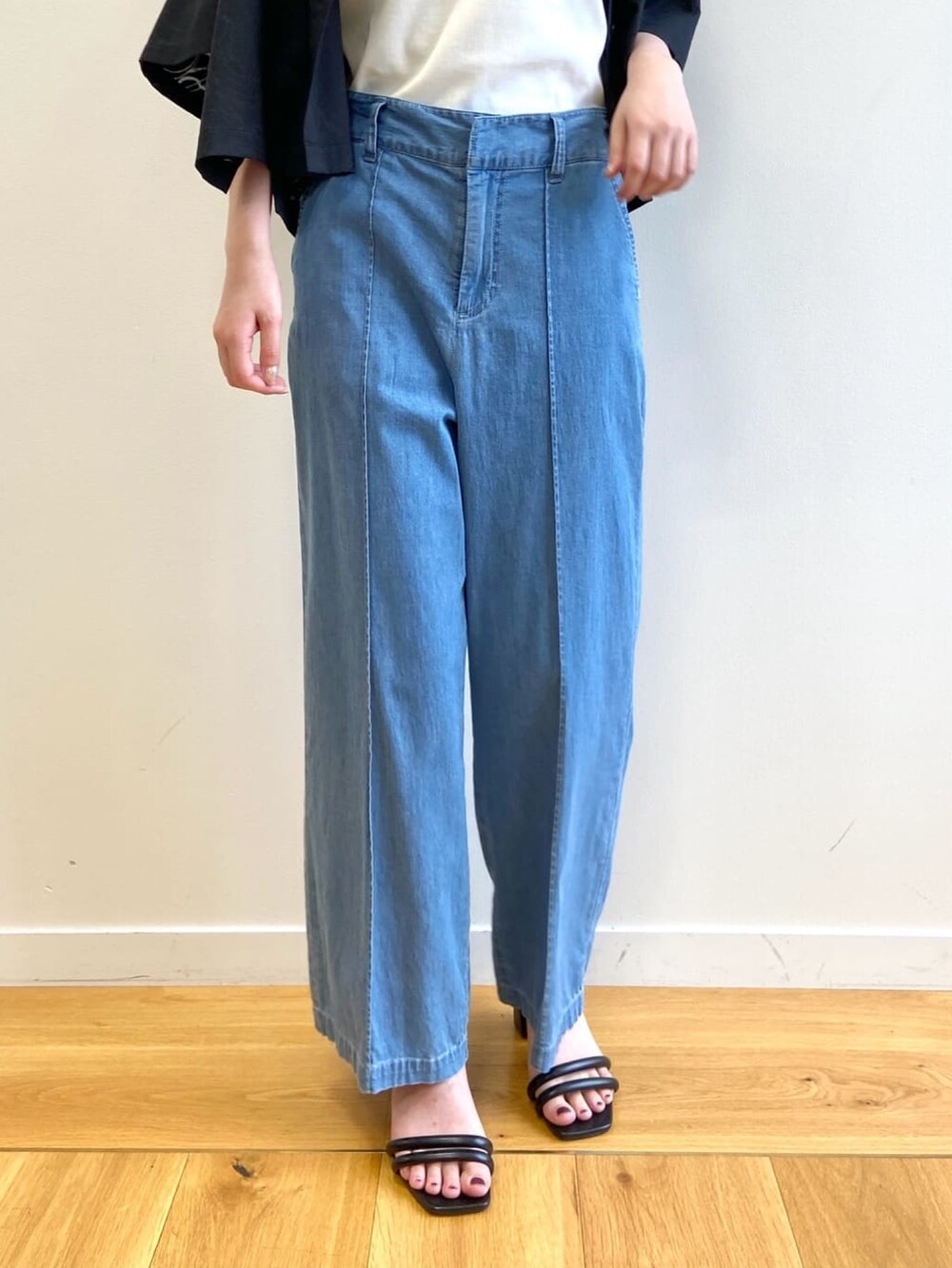 ブルー系のデニムパンツ、ブラック系のサンダル、ブラック系のシャツ/ブラウスを着用したレディースの夏コーディネートの8枚目の写真