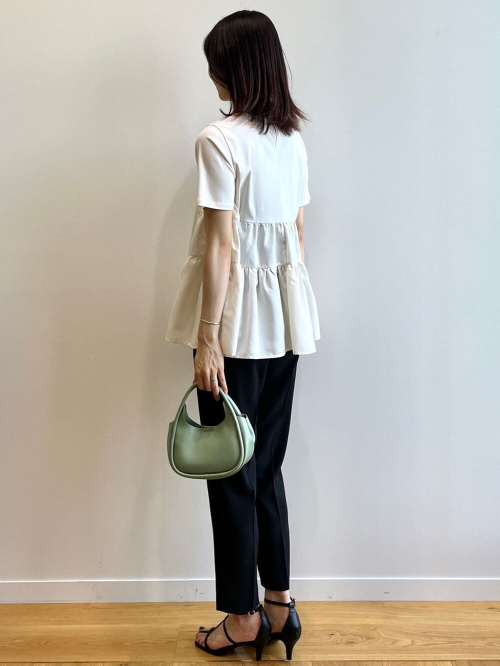 ホワイト系のTシャツ/カットソー、ブラック系のその他パンツ、ブラック系のサンダルを着用したレディースの秋コーディネートの3枚目の写真