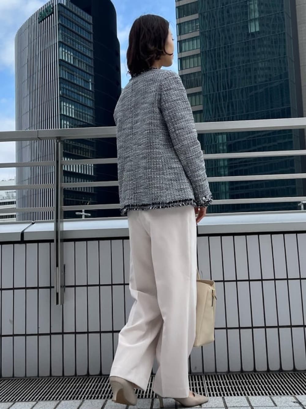 ブラック系のノーカラージャケット、ベージュ系のその他パンツ、ホワイト系のシャツ/ブラウスを着用したレディースの冬コーディネートの2枚目の写真