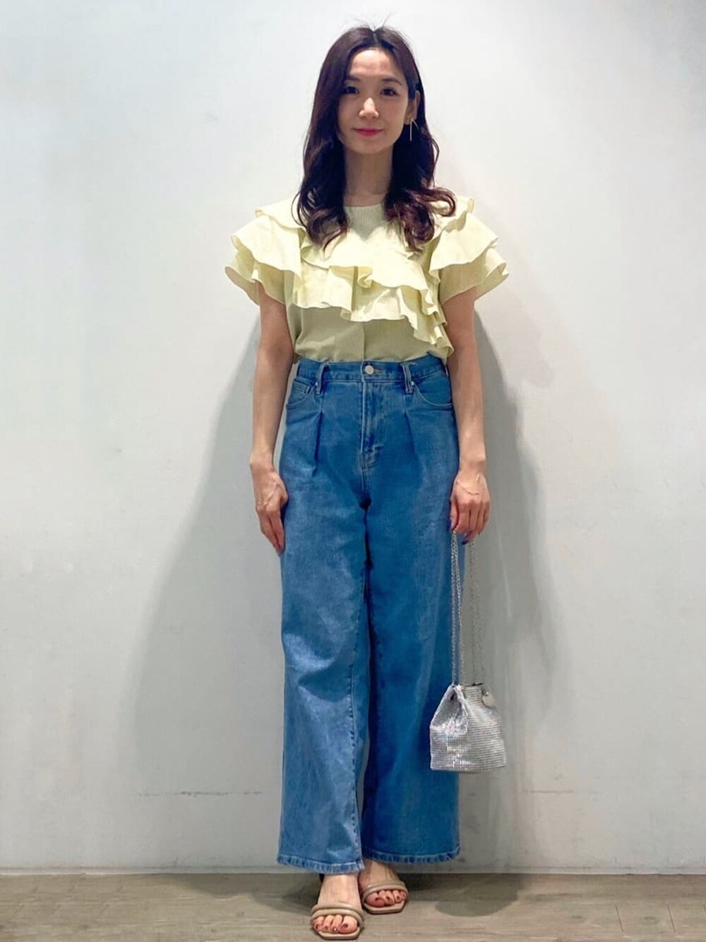 イエロー系のシャツ/ブラウス、ブルー系のデニムパンツ、ホワイト系のショルダーバッグを着用したレディースの春コーディネートの4枚目の写真