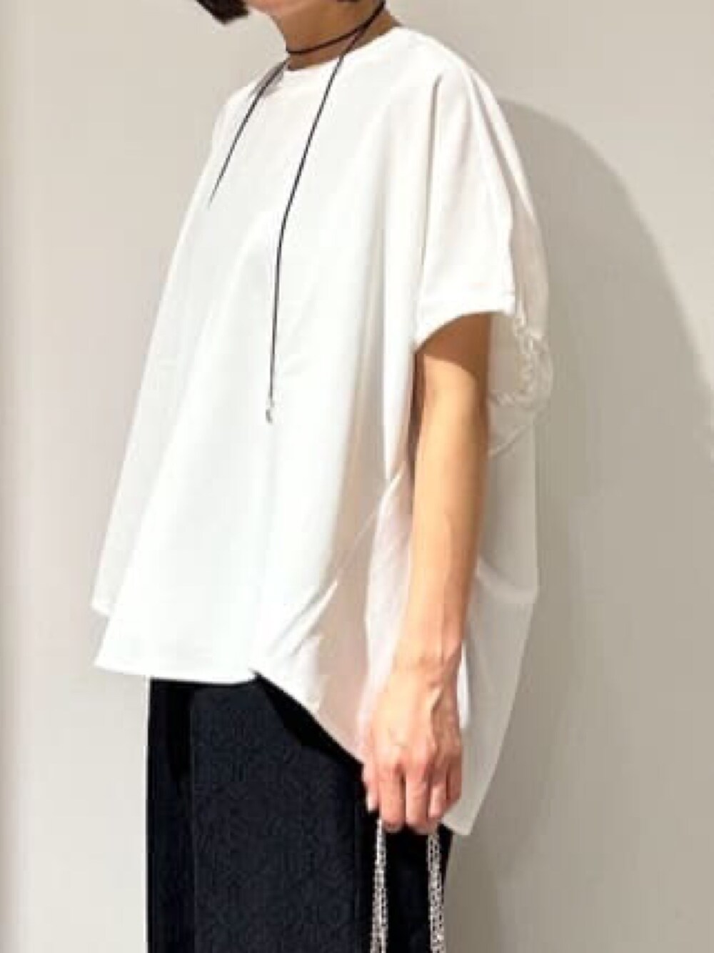 ホワイト系のTシャツ/カットソー、ブラック系のその他パンツ、ブラック系のサンダルを着用したレディースの春コーディネートの6枚目の写真