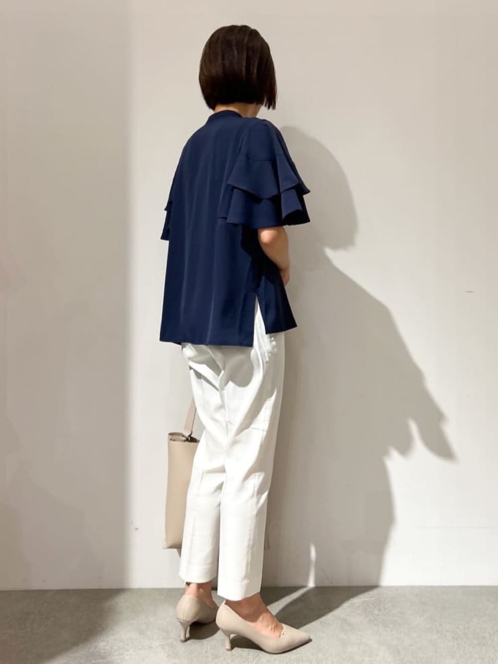 ブルー系のシャツ/ブラウス、ホワイト系のその他パンツ、ベージュ系のショルダーバッグを着用したレディースの夏コーディネートの3枚目の写真