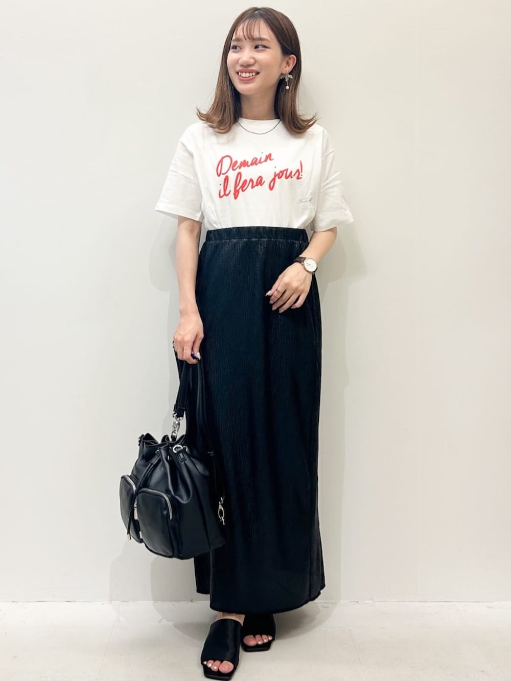 ホワイト系のTシャツ/カットソー、ブラック系のスカート、ブラック系のショルダーバッグを着用したレディースの夏コーディネートの2枚目の写真