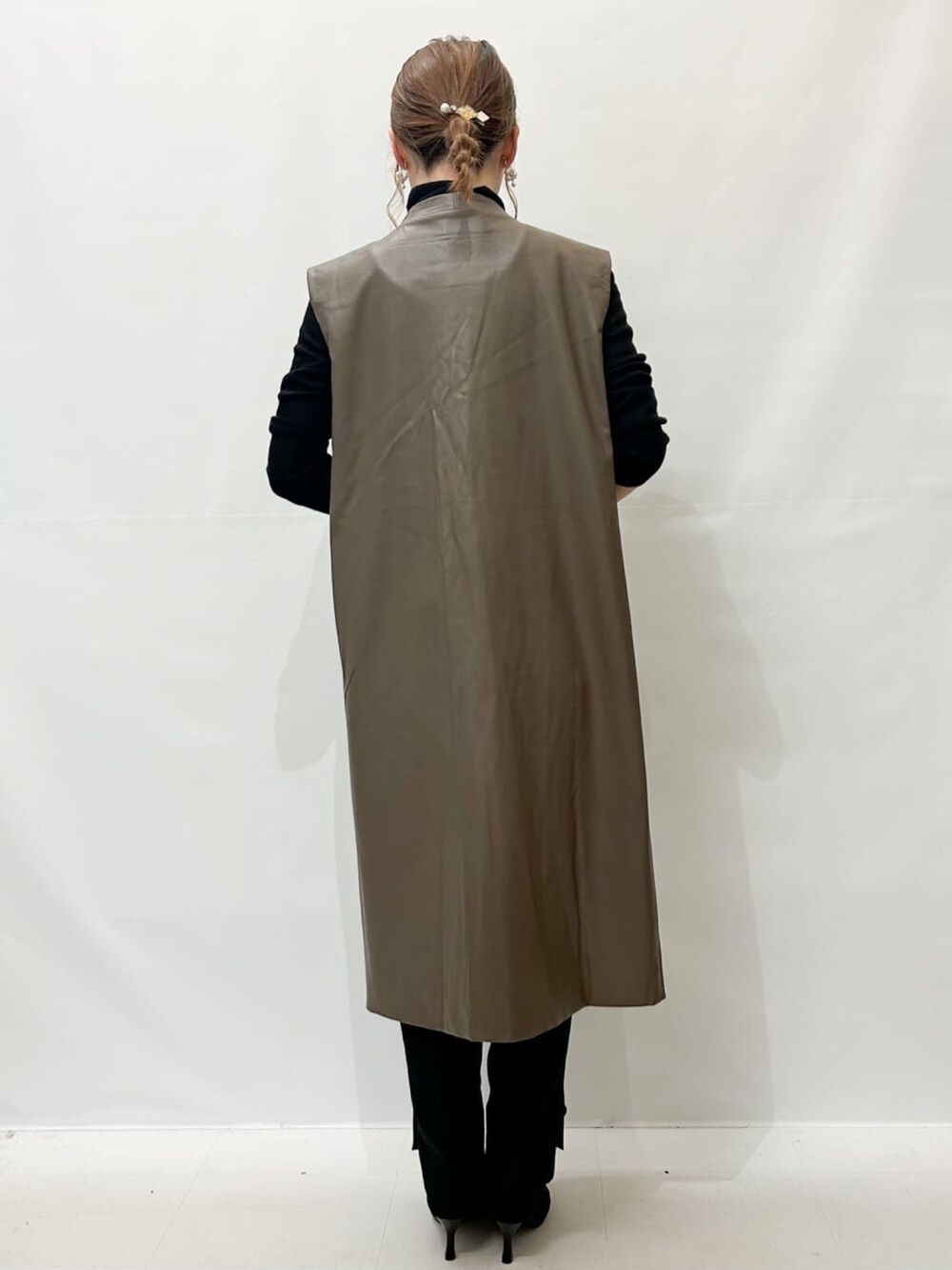 ブラック系のブーツ、ホワイト系のショルダーバッグ、ブラック系のニット/セーターを着用したレディースの秋コーディネートの3枚目の写真