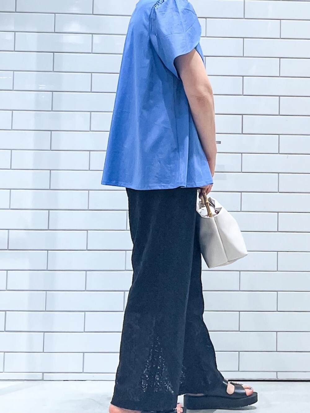 ブルー系のTシャツ/カットソー、ブラック系のサンダル、ホワイト系のショルダーバッグを着用したレディースの春コーディネートの3枚目の写真