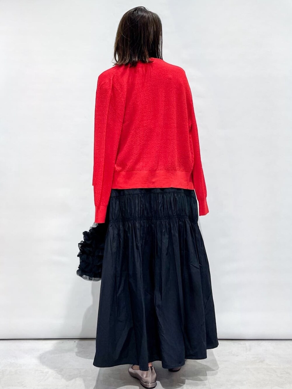 レッド系のカーディガン/ボレロ、レッド系のニット/セーター、ブラック系のスカートを着用したレディースの夏コーディネートの5枚目の写真