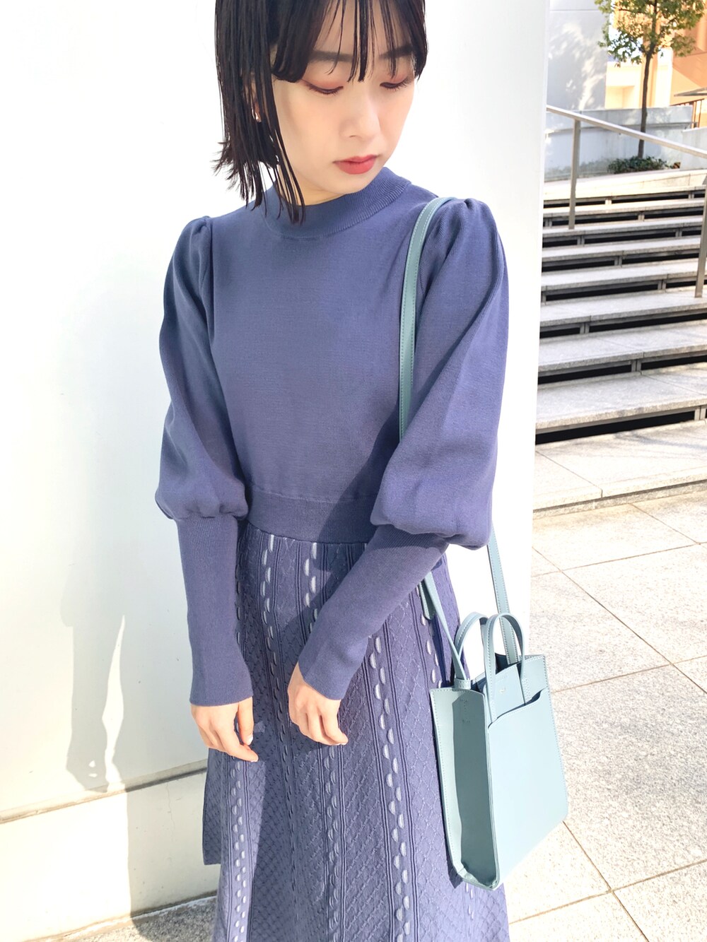 ブルー系のワンピース、ブルー系のショルダーバッグ、シルバー系のドレスシューズを着用したレディースの冬コーディネートの2枚目の写真