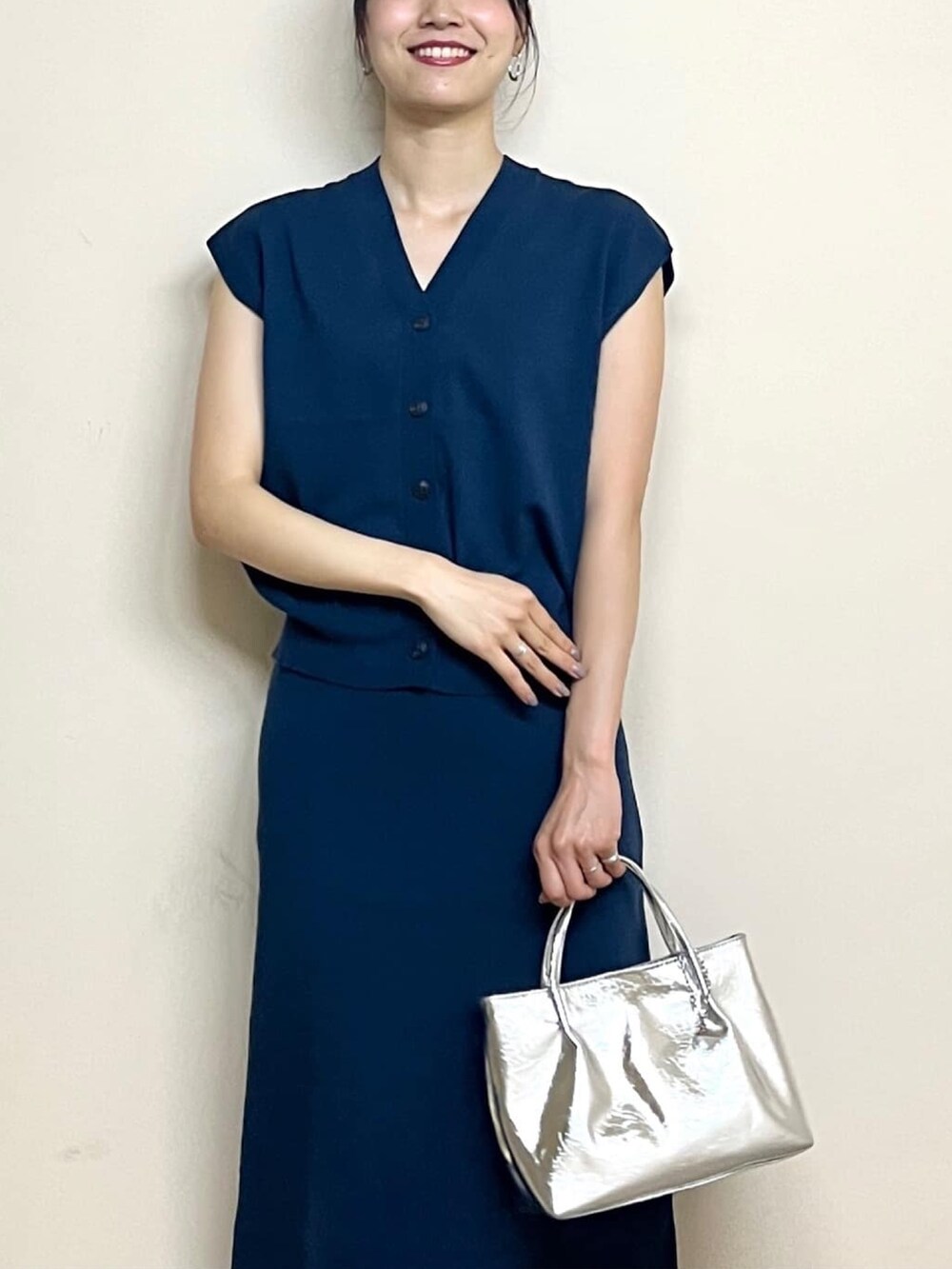 ブルー系のベスト、ブルー系のスカート、シルバー系のトートバッグを着用したレディースの夏コーディネートの5枚目の写真