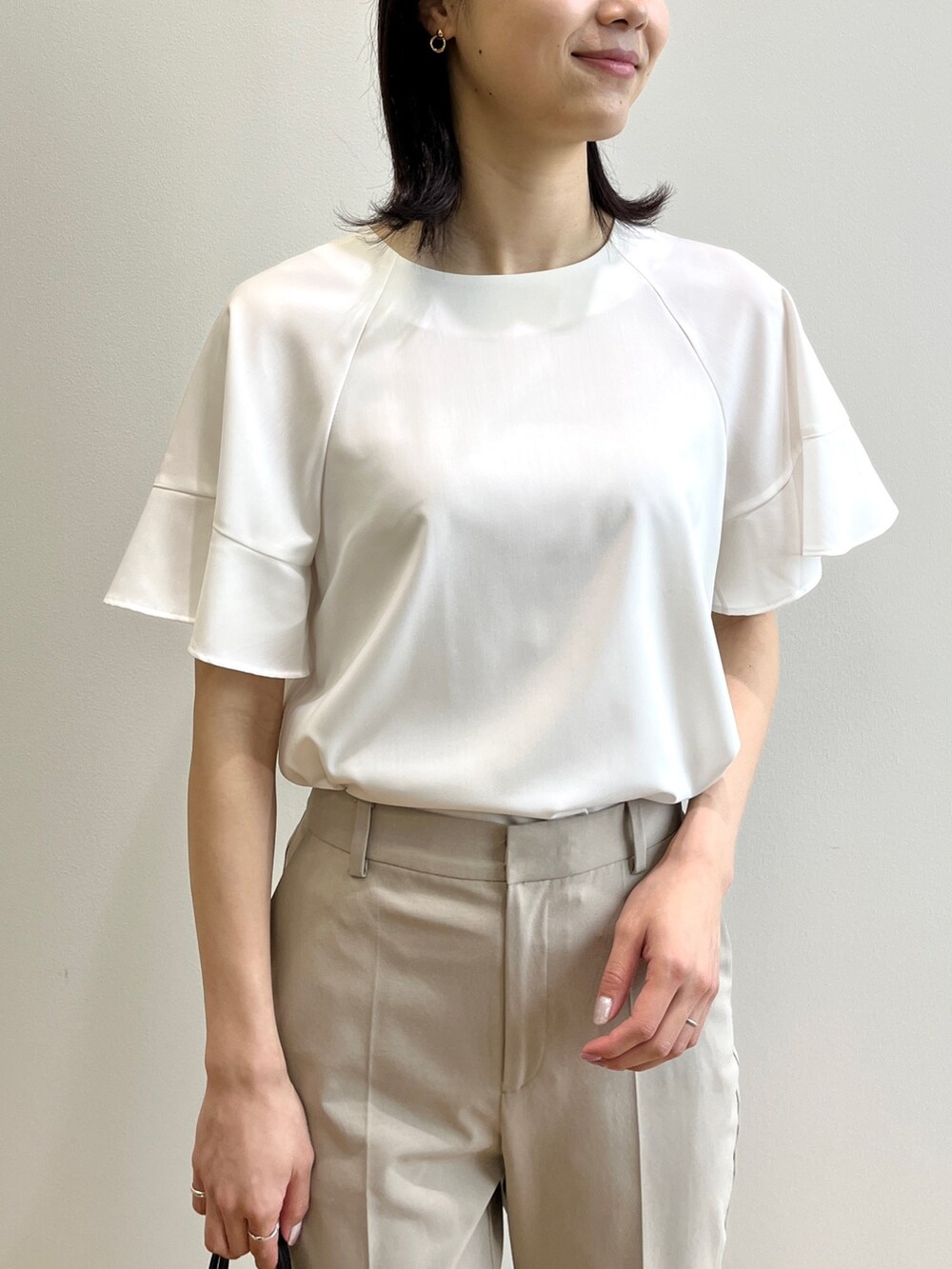 ホワイト系のシャツ/ブラウス、ベージュ系のその他パンツ、ブラック系のサンダルを着用したレディースの春コーディネートの3枚目の写真