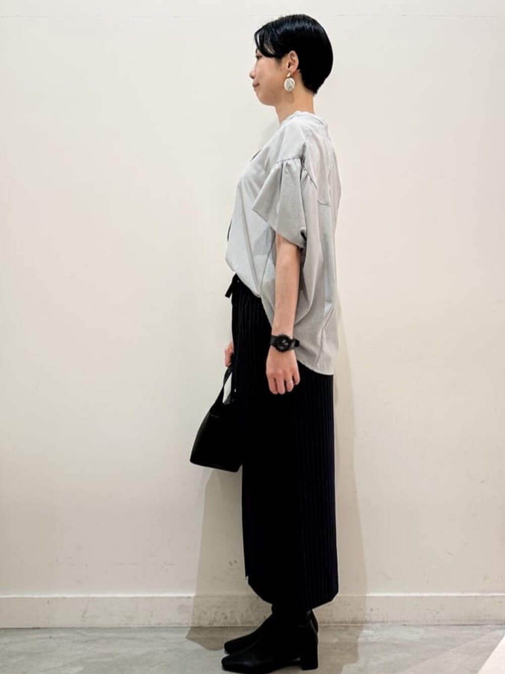 グリーン系のシャツ/ブラウス、ブルー系のスカート、ブラック系のトートバッグを着用したレディースの夏コーディネートの3枚目の写真