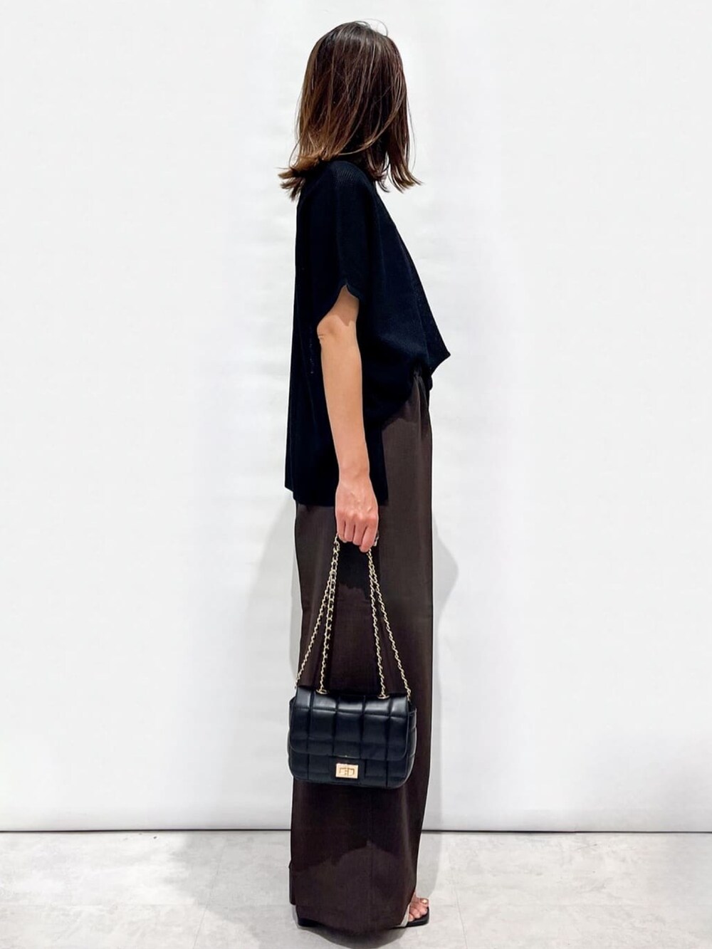 ブラウン系のその他パンツ、ホワイト系のサンダル、ブラック系のショルダーバッグを着用したレディースの夏コーディネートの5枚目の写真