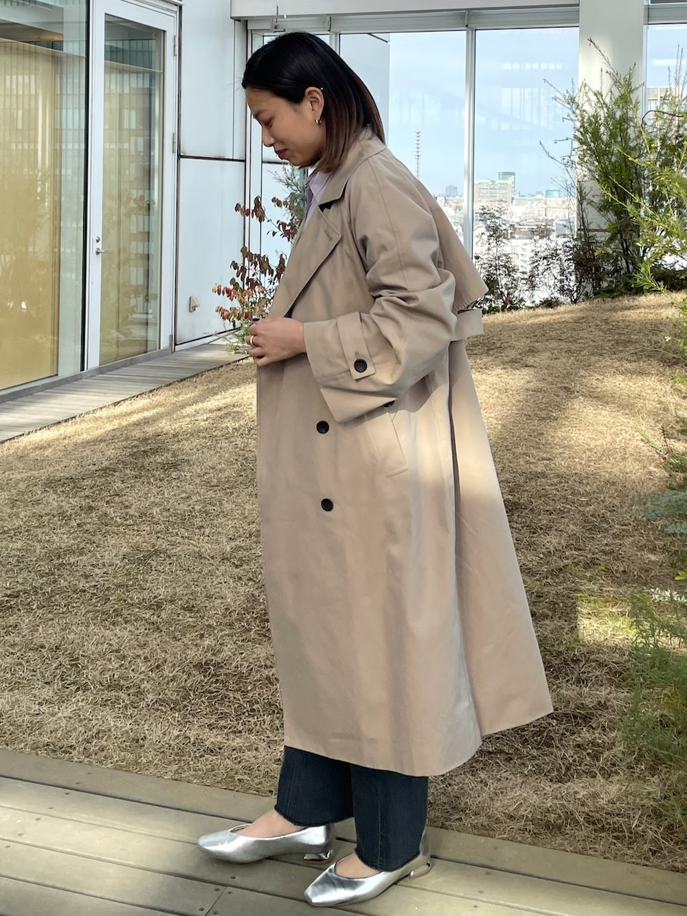 パープル系のシャツ/ブラウス、ベージュ系のトレンチコート、シルバー系のその他シューズを着用したレディースの冬コーディネートの2枚目の写真