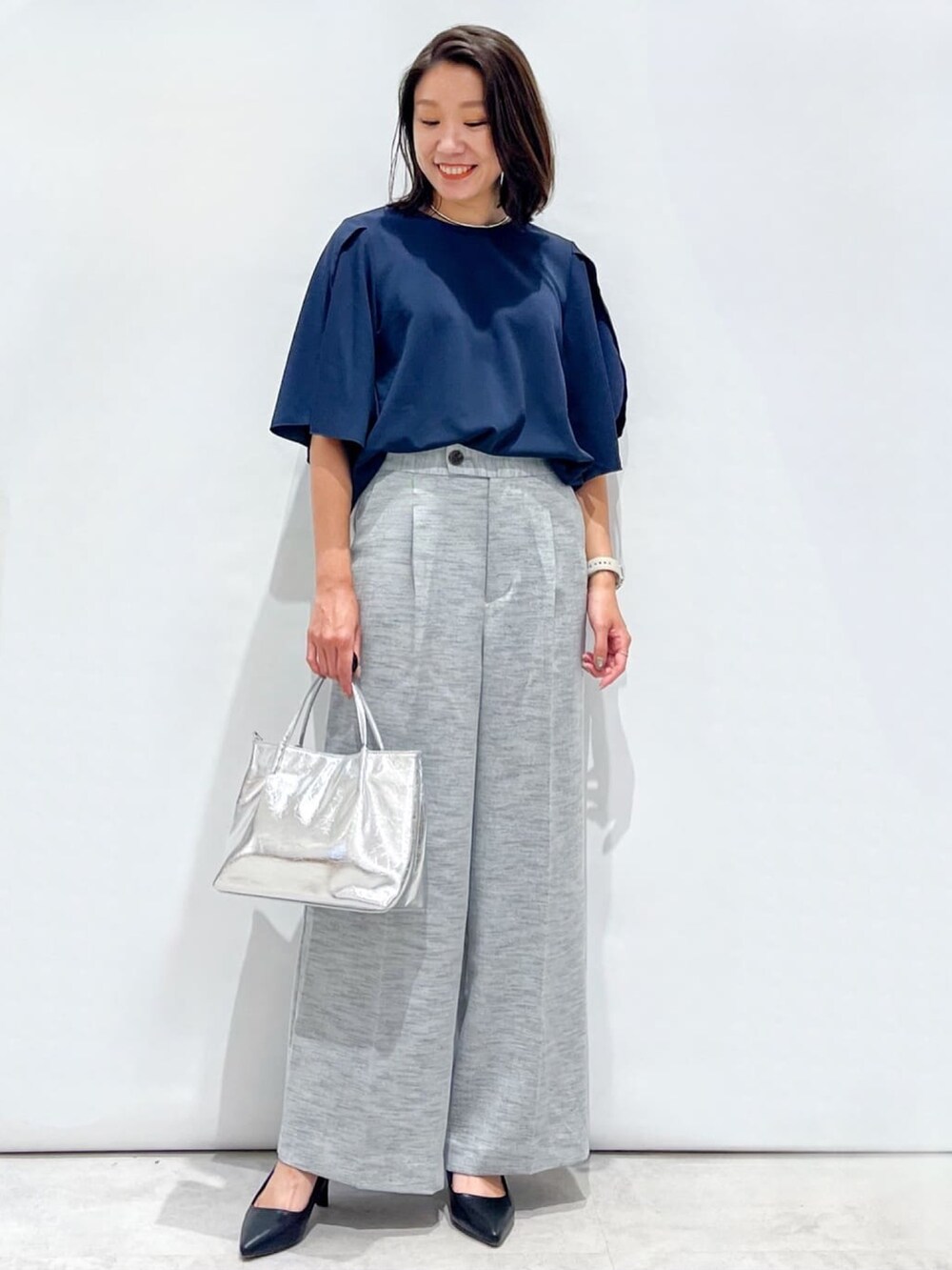 ブラック系のその他パンツ、ブラック系のパンプス、シルバー系のトートバッグを着用したレディースの夏コーディネートの2枚目の写真