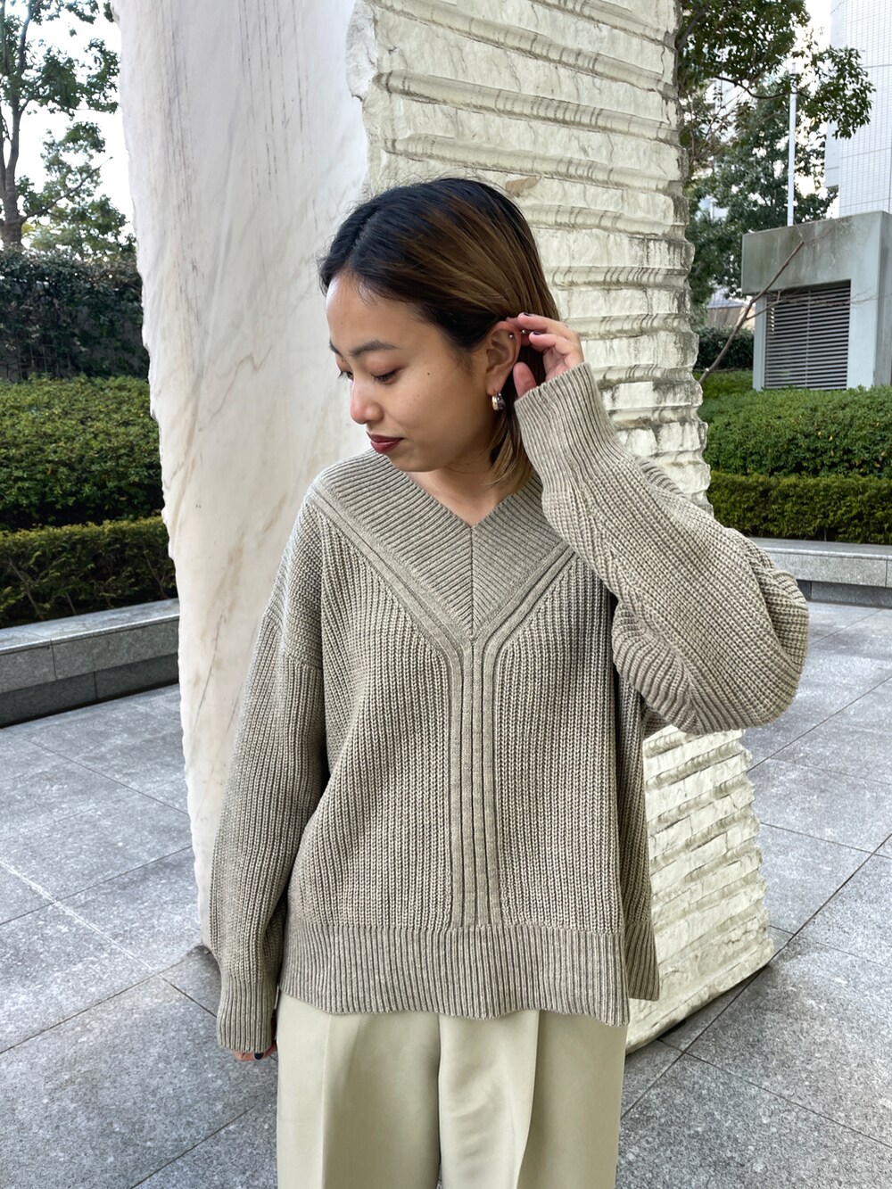 ベージュ系のニット/セーター、グリーン系のその他パンツ、ベージュ系のショルダーバッグを着用したレディースの冬コーディネートの2枚目の写真