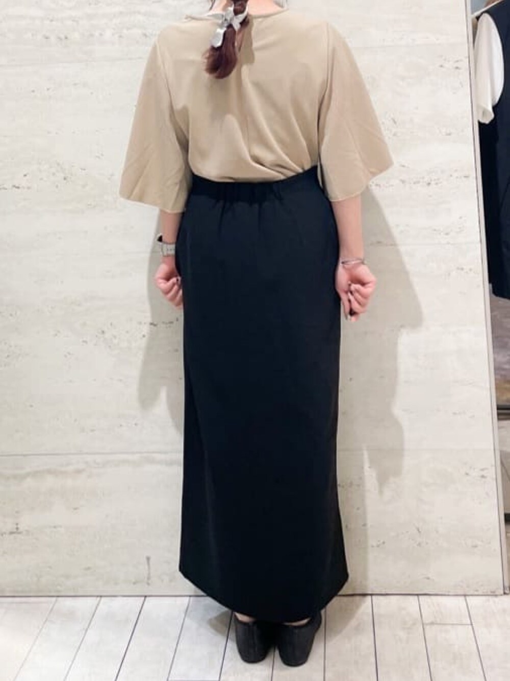 ベージュ系のTシャツ/カットソー、ブラック系のスカート、ブラック系のパンプスを着用したレディースの秋コーディネートの4枚目の写真