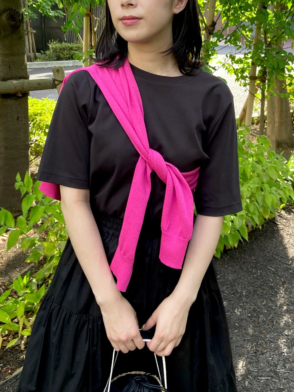 ピンク系のカーディガン/ボレロ、ブラック系のTシャツ/カットソー、ブラック系のスカートを着用したレディースの夏コーディネートの4枚目の写真