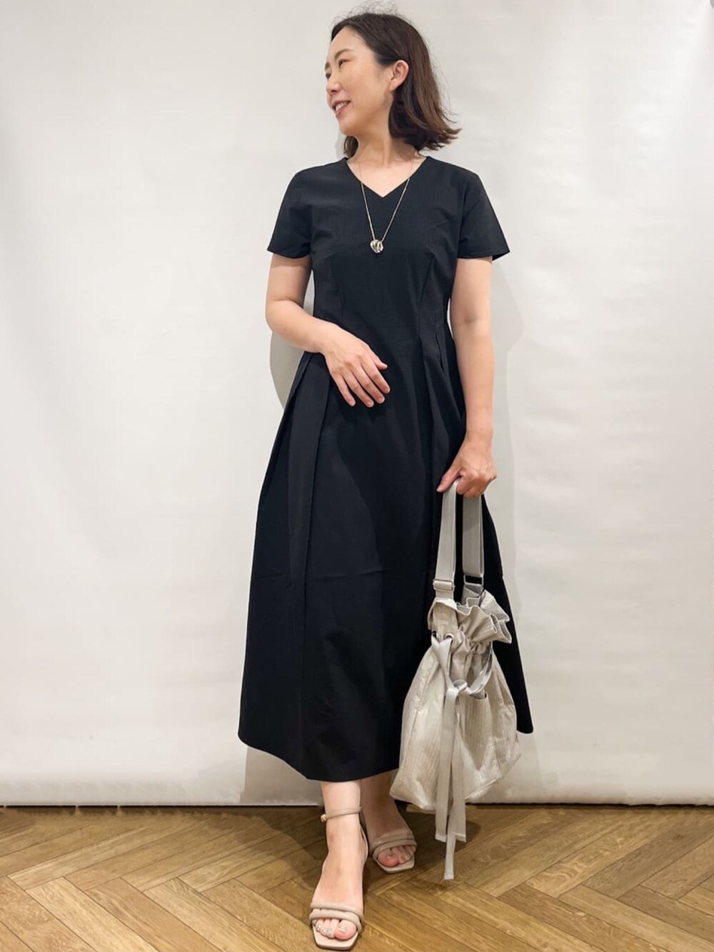 ブラック系のワンピース、ホワイト系のカーディガン/ボレロ、ホワイト系のトートバッグを着用したレディースの夏コーディネートの4枚目の写真