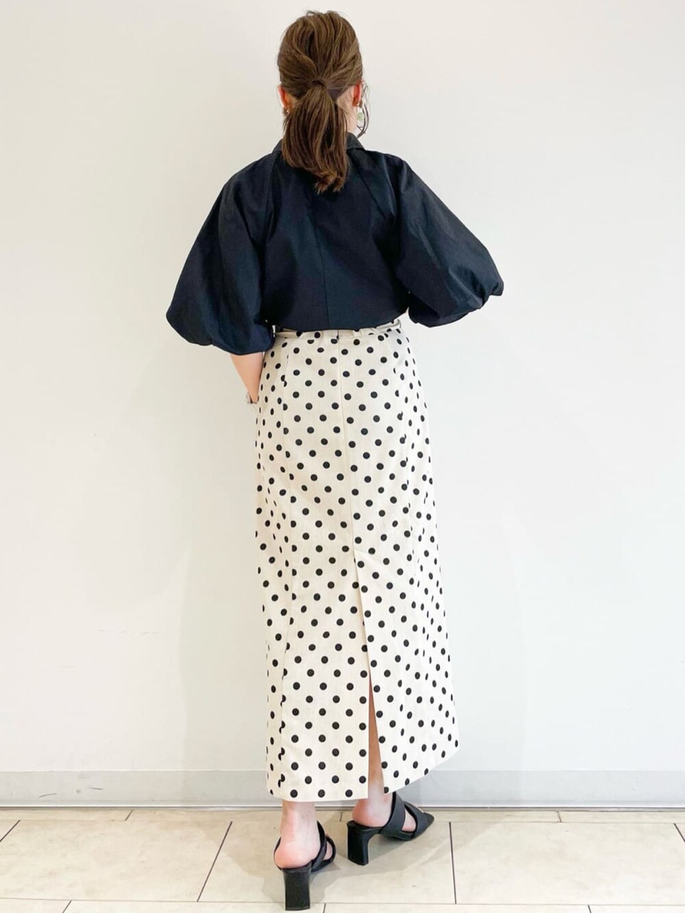 ブラック系のシャツ/ブラウス、ホワイト系のスカート、レッド系のショルダーバッグを着用したレディースの春コーディネートの3枚目の写真