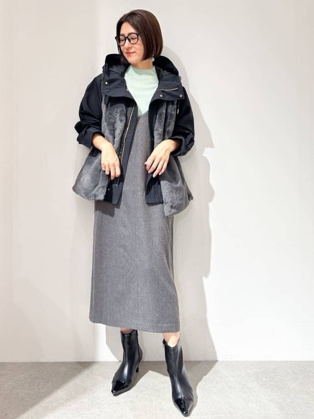 ブラック系のブルゾン、グリーン系のニット/セーター、ブラック系のスカートを着用したレディースの秋コーディネートの5枚目の写真