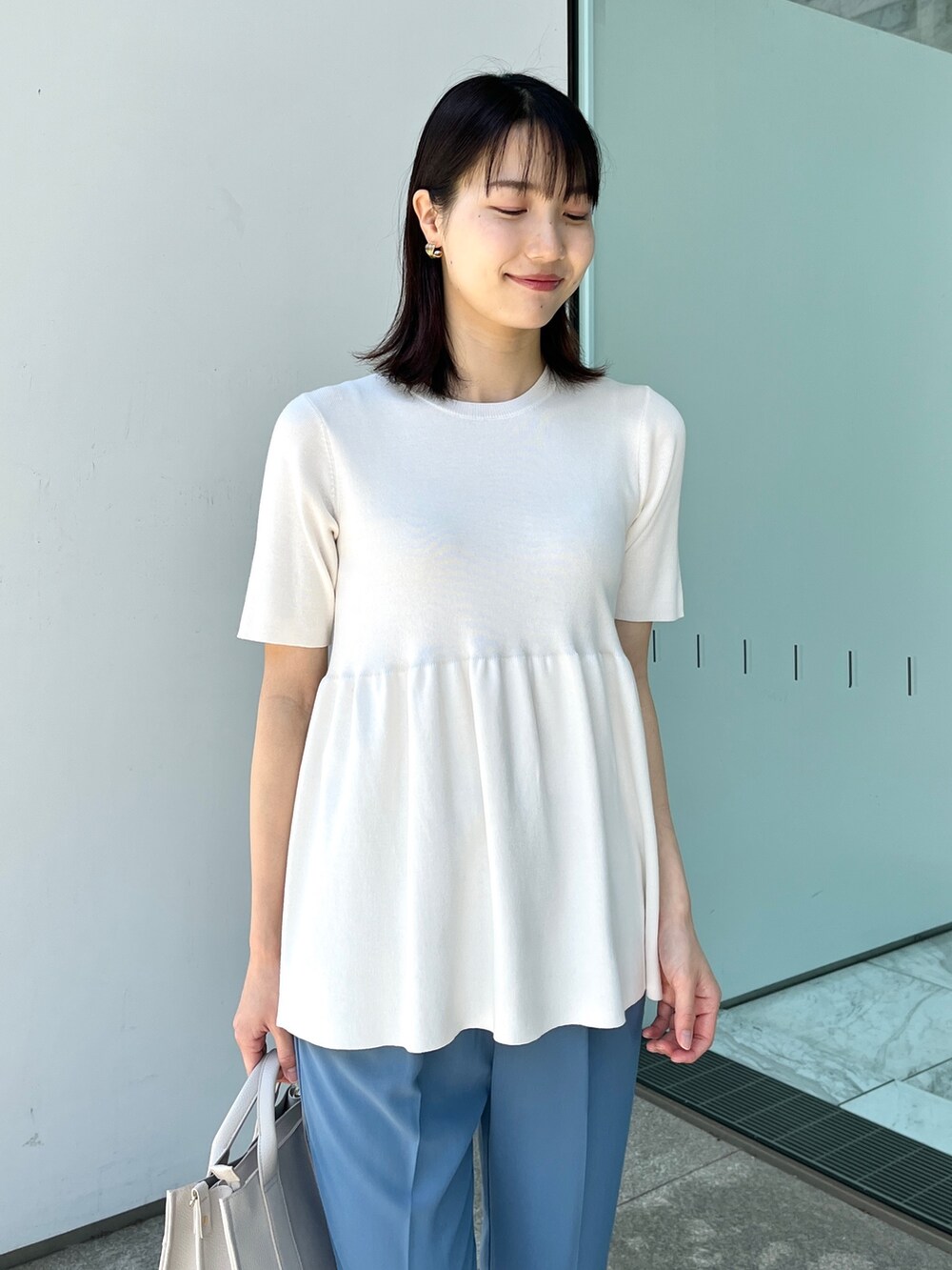 ホワイト系のニット/セーター、ブルー系のその他パンツ、ゴールド系のサンダルを着用したレディースの春コーディネートの4枚目の写真