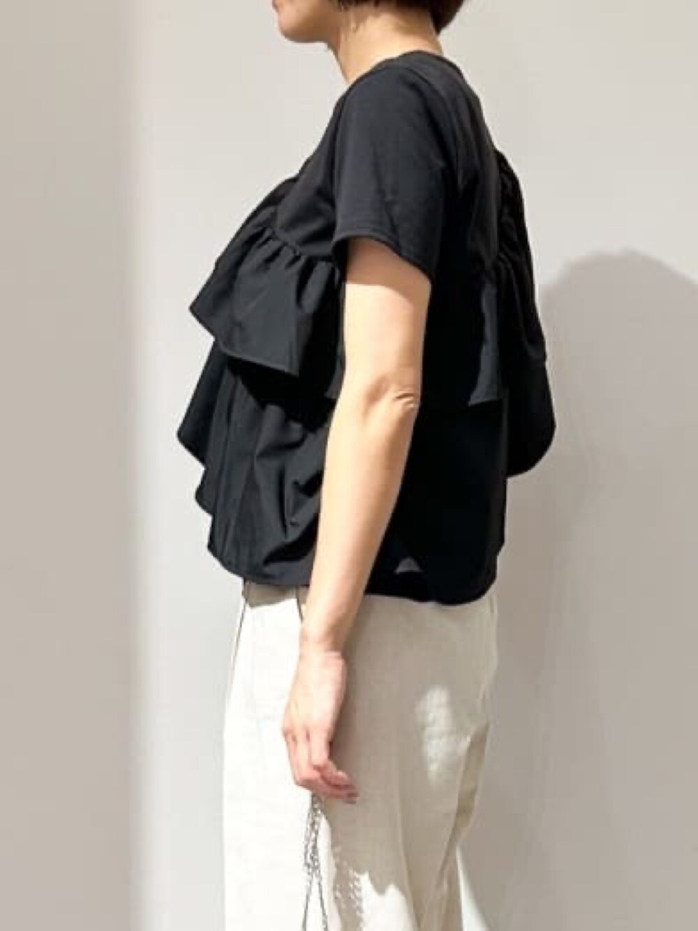 ブラック系のTシャツ/カットソー、ホワイト系のその他パンツ、ブラック系のサンダルを着用したレディースの夏コーディネートの4枚目の写真