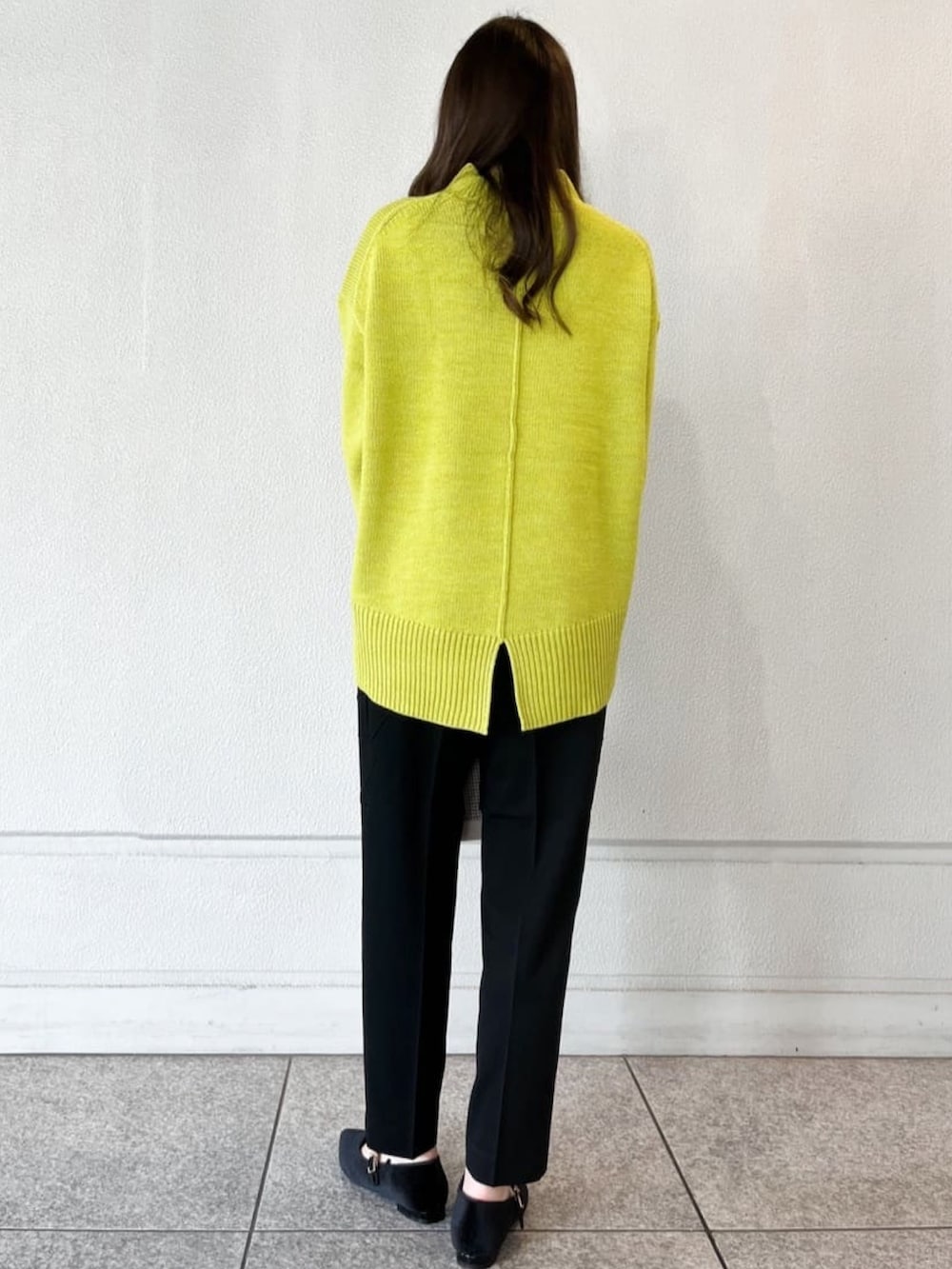 グリーン系のニット/セーター、ブラック系のその他パンツ、ベージュ系のショルダーバッグを着用したレディースの冬コーディネートの3枚目の写真