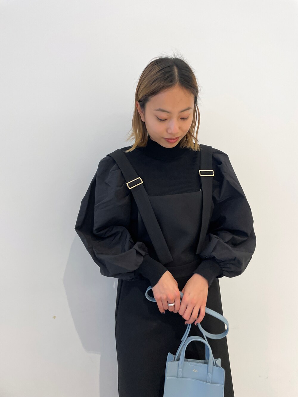 ブラック系のニット/セーター、ブラック系のスカート、ブラウン系のドレスシューズを着用したレディースの冬コーディネートの2枚目の写真