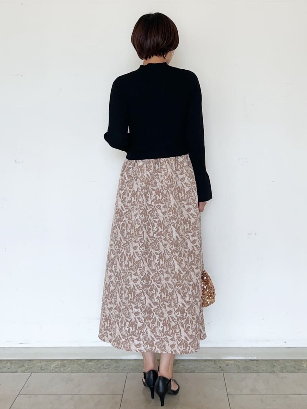 ベージュ系のワンピース、ブラウン系のショルダーバッグ、ブラック系のパンプスを着用したレディースの秋コーディネートの4枚目の写真