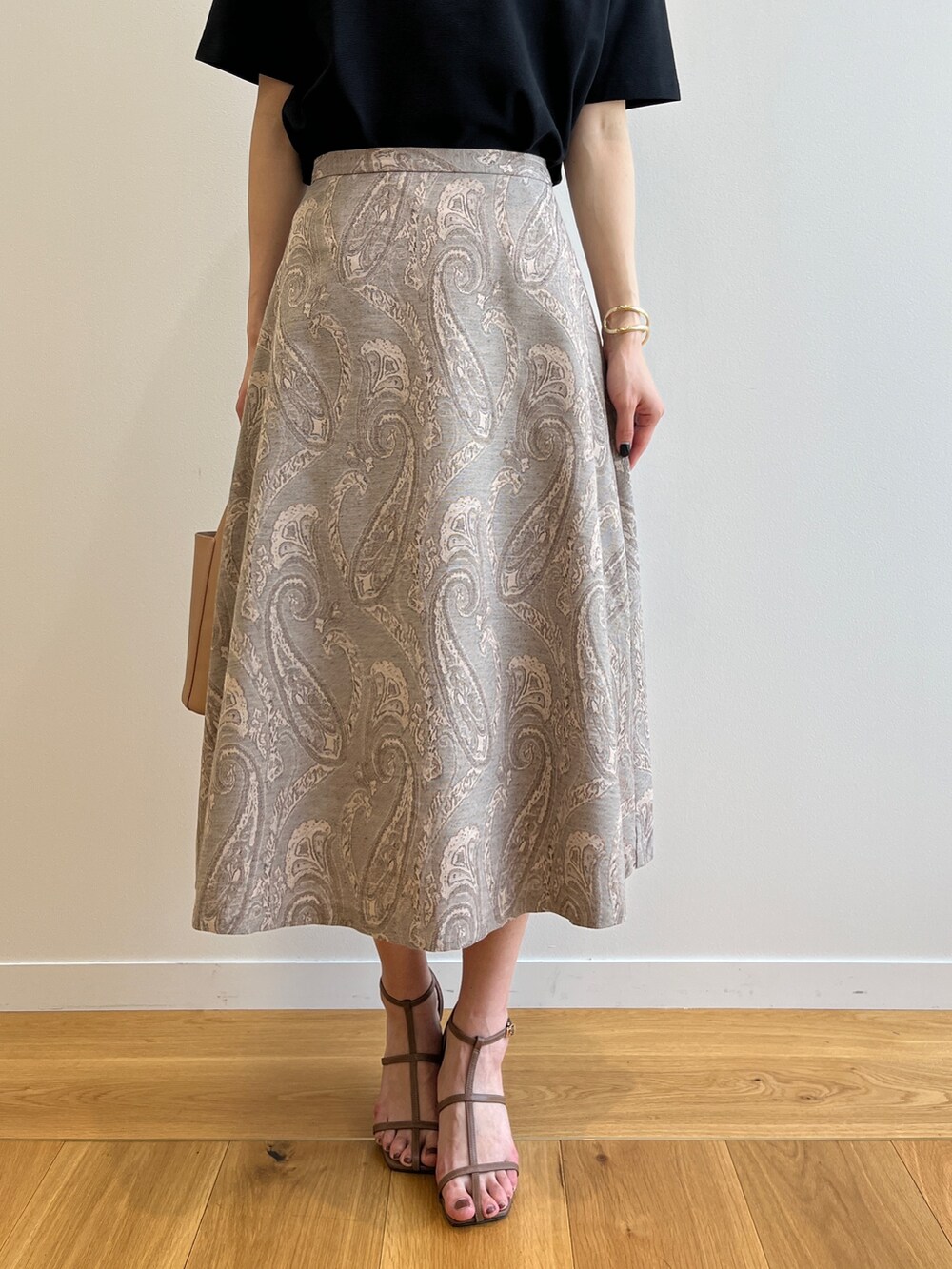 ブラウン系のサンダル、ベージュ系のスカート、イエロー系のトートバッグを着用したレディースの夏コーディネートの4枚目の写真