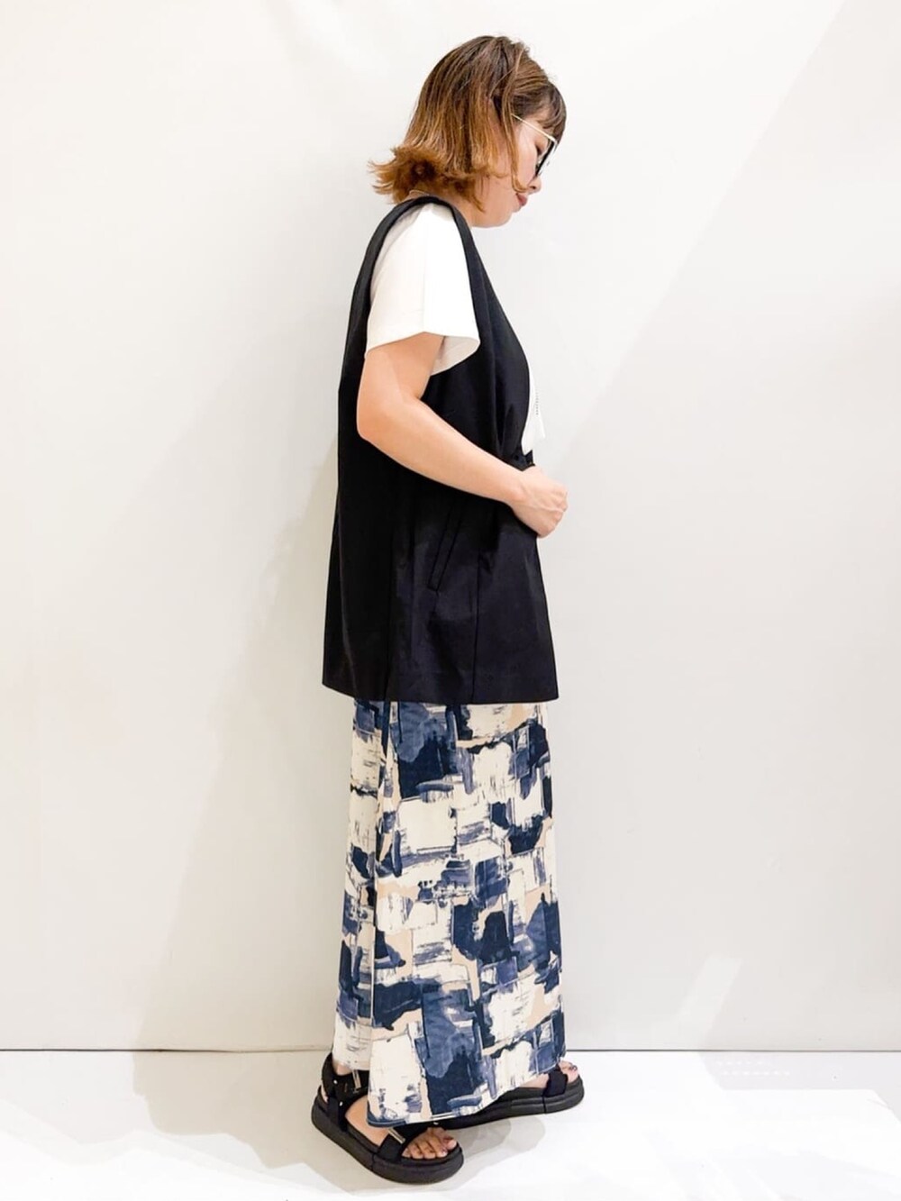 ホワイト系のTシャツ/カットソー、ブラック系のベスト、シルバー系のトートバッグを着用したレディースの夏コーディネートの5枚目の写真