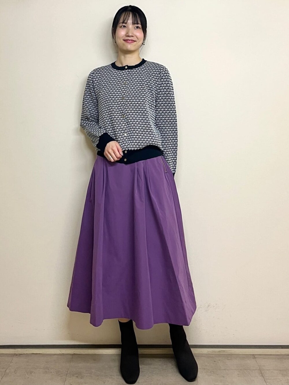 ホワイト系のカーディガン/ボレロ、パープル系のスカート、ブラック系のブーツを着用したレディースの夏コーディネートの2枚目の写真