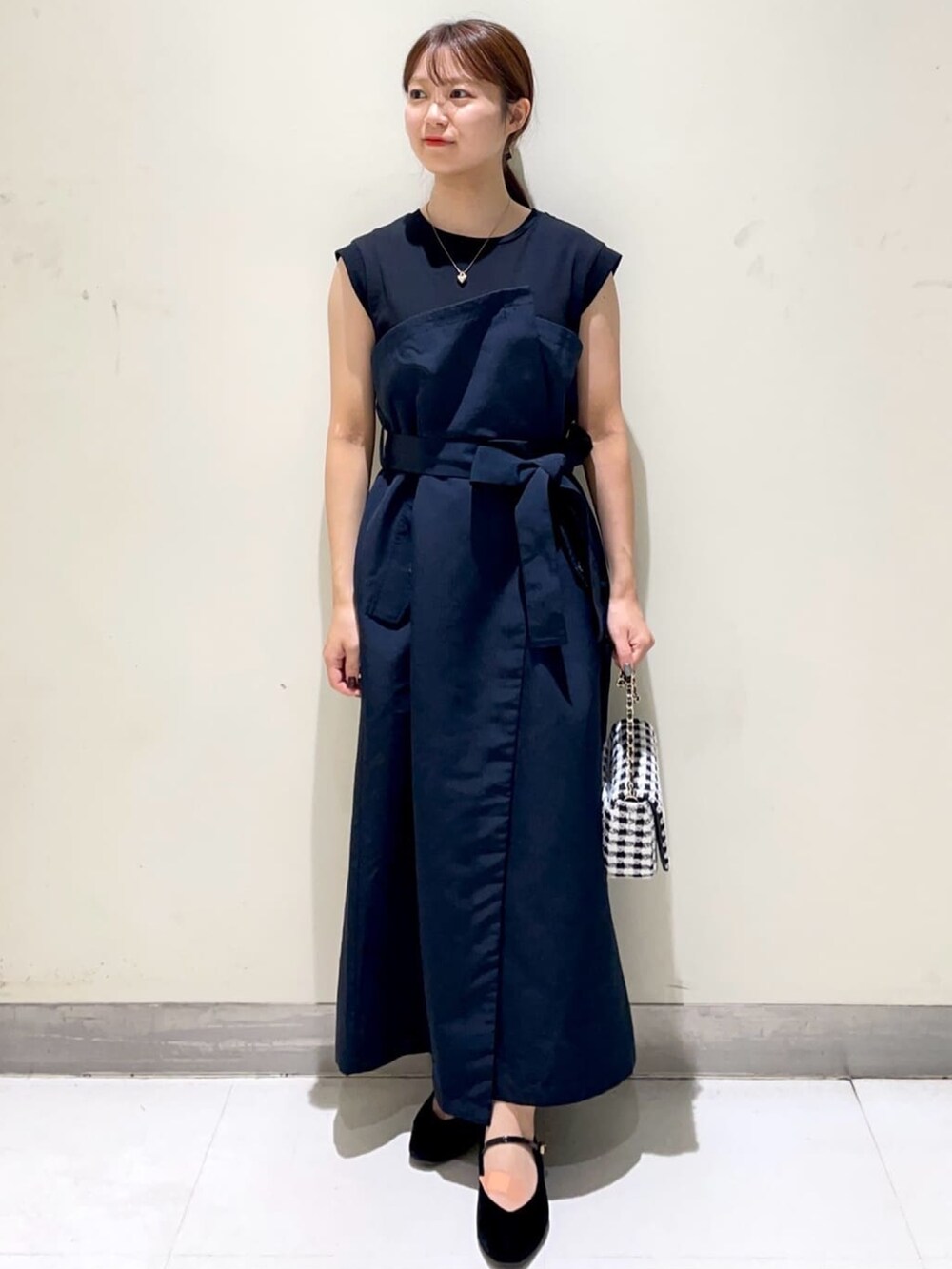 ブルー系のワンピース、ブラック系のパンプス、ブラック系のショルダーバッグを着用したレディースの秋コーディネートの2枚目の写真