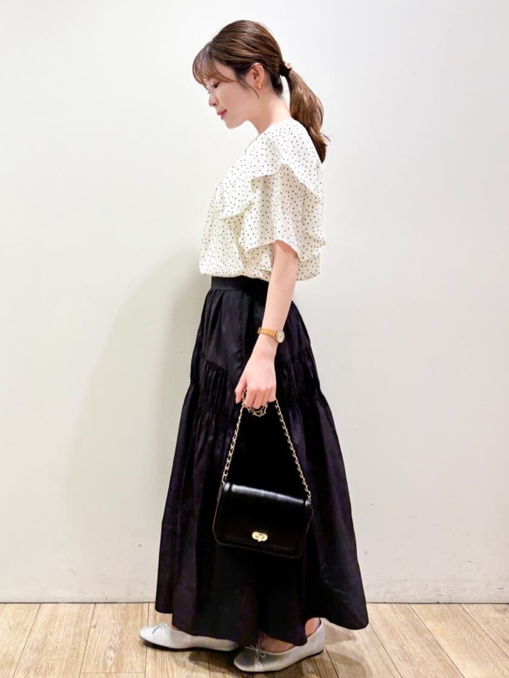 ホワイト系のシャツ/ブラウス、ブラック系のスカート、ブラック系のショルダーバッグを着用したレディースの夏コーディネートの2枚目の写真