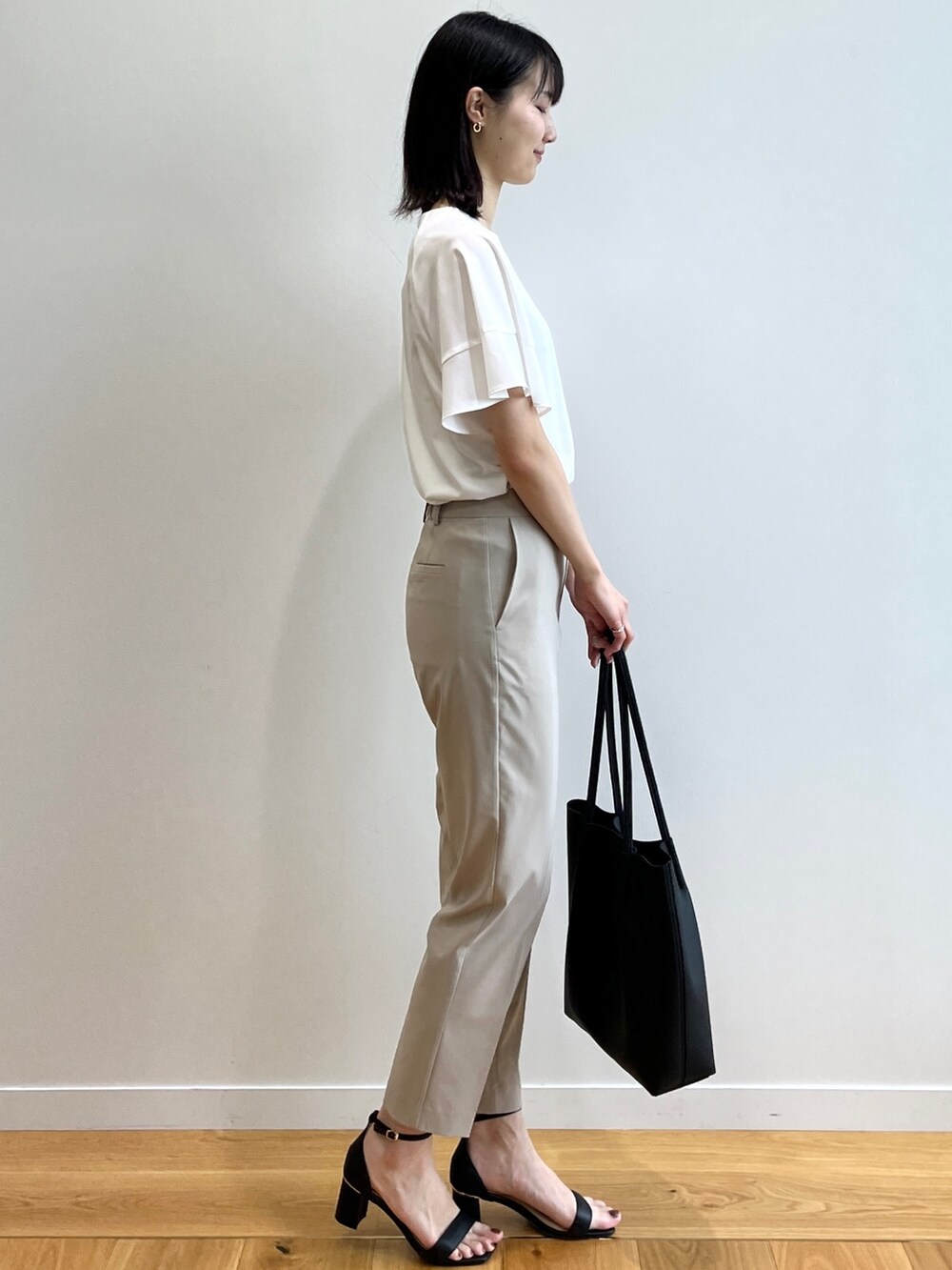 ホワイト系のシャツ/ブラウス、ベージュ系のその他パンツ、ブラック系のサンダルを着用したレディースの春コーディネートの2枚目の写真
