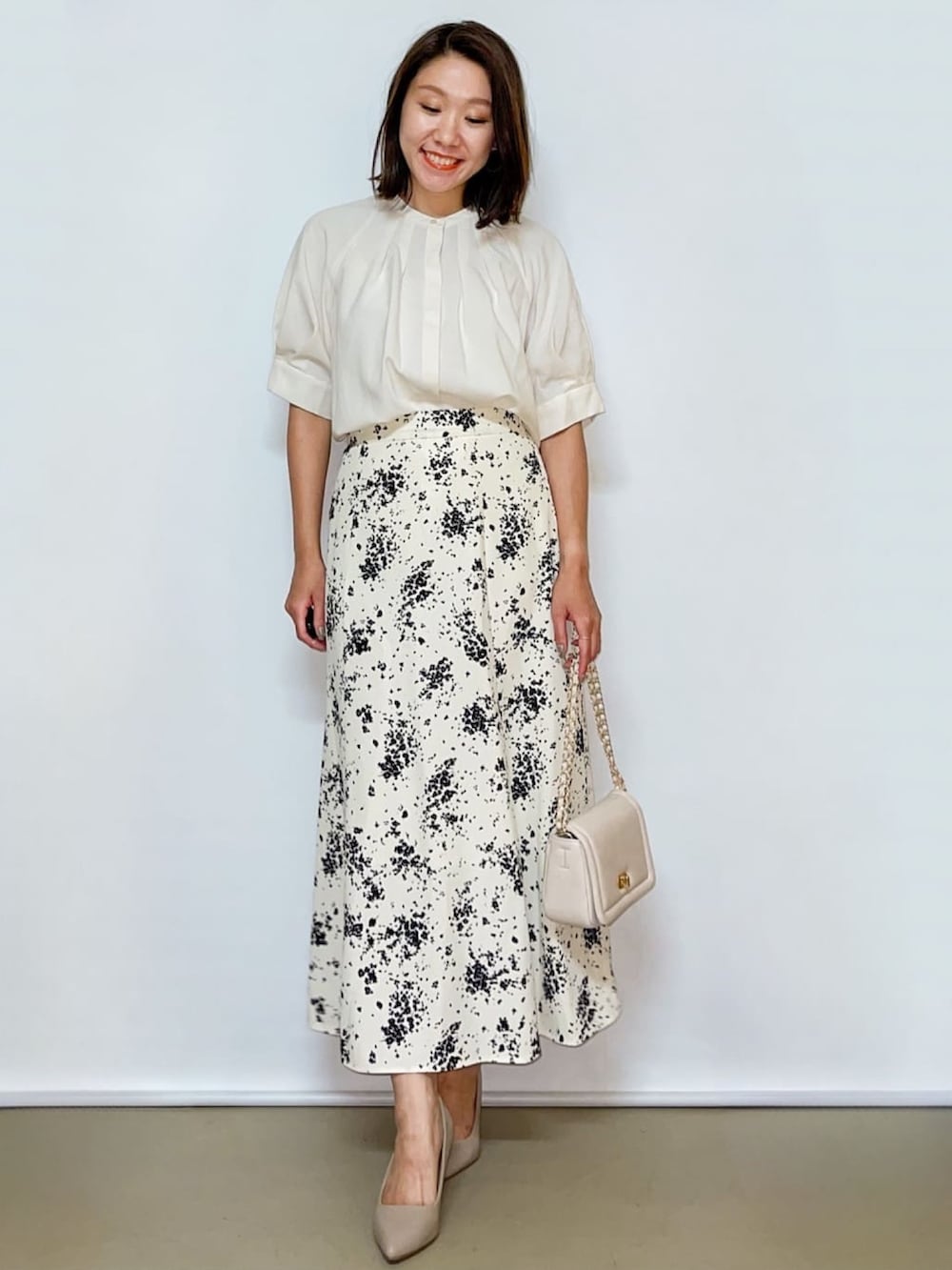 ホワイト系のシャツ/ブラウス、ホワイト系のスカート、ホワイト系のショルダーバッグを着用したレディースの夏コーディネートの2枚目の写真