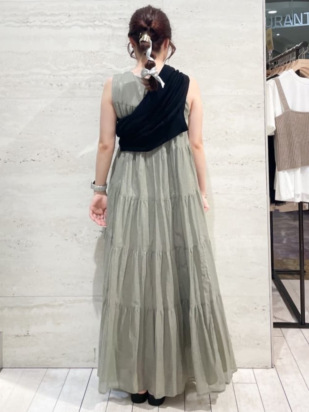 グリーン系のワンピース、シルバー系のショルダーバッグ、ブラック系のサンダルを着用したレディースの夏コーディネートの4枚目の写真