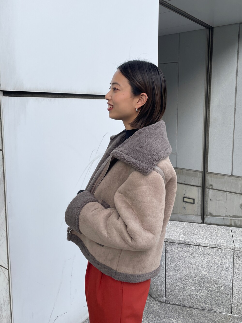 ブラウン系のブルゾン、ブラック系のニット/セーター、ブラック系のブーツを着用したレディースの秋コーディネートの3枚目の写真