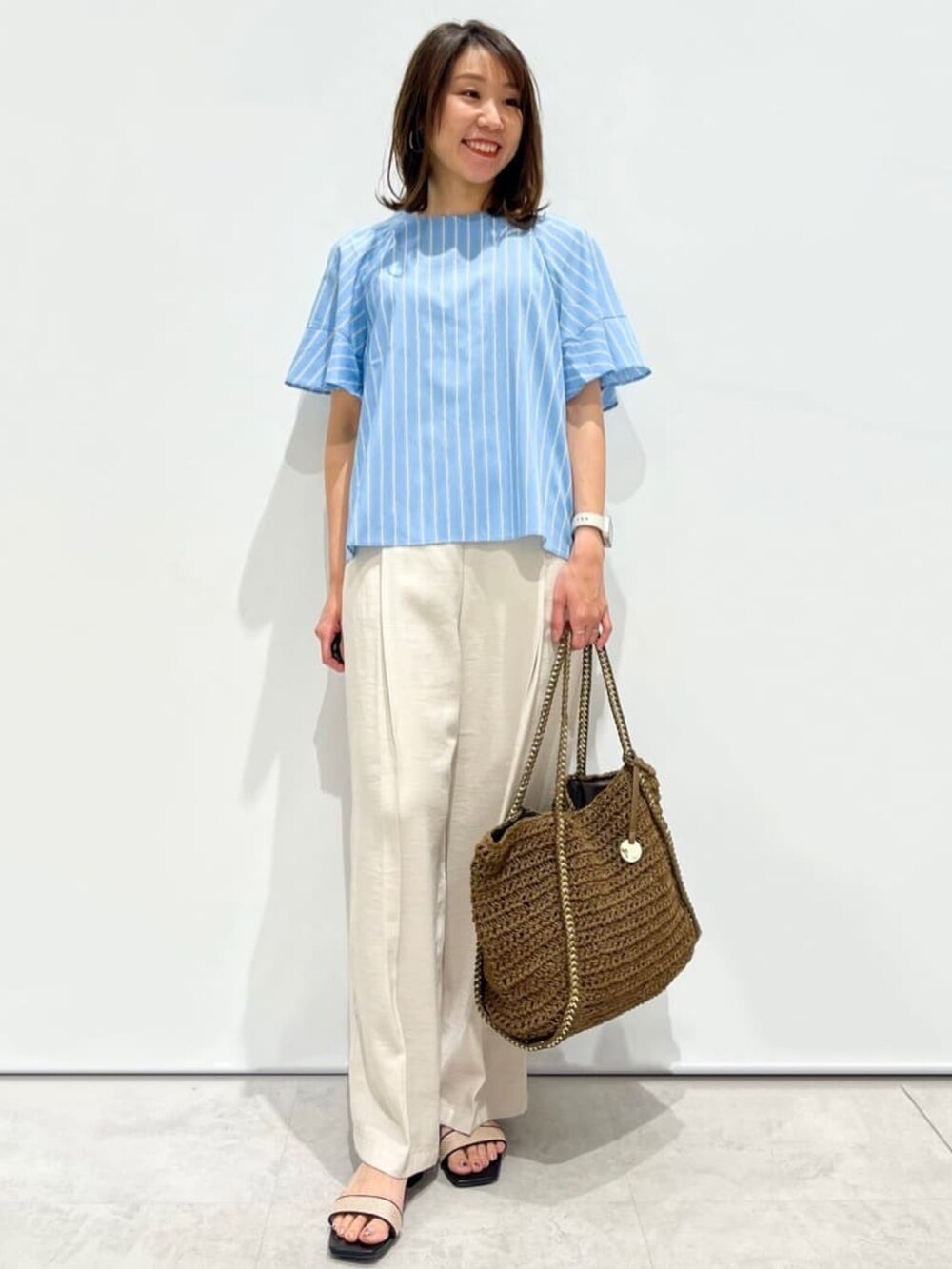 ブルー系のシャツ/ブラウス、ベージュ系のその他パンツ、ブラウン系のトートバッグを着用したレディースの春コーディネートの3枚目の写真